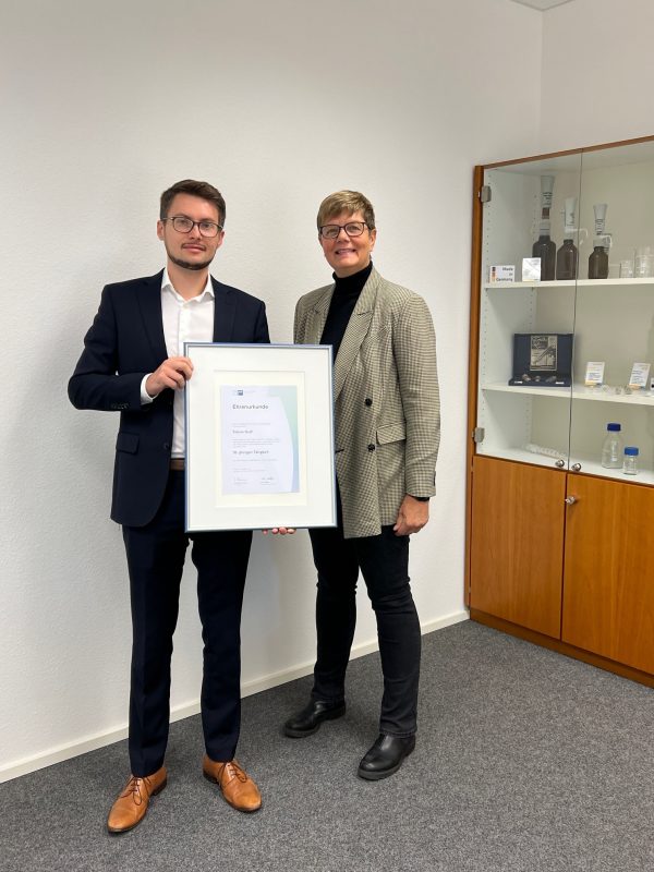 Übergabe der IHK-Urkunde zum 10-jährigen Jubiläum von Tobias Graf, überreicht von Heide Fahrenkrog-Keller