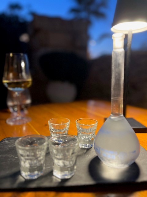Raki in einem 100 ml Messkolben, dazu 4 Schnapsgläser